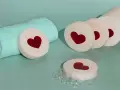 Jabones de glicerina con corazones rojos, listos para hacer jabón. Toalla turquesa y burbujas.
