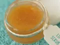 Un tarro de exfoliante de labios casero con etiqueta "Lip Scrub" sobre una toalla turquesa.