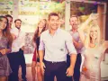 Grupo de amigos celebrando con confeti, listos para juegos de despedida de soltero.