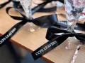 Copas de champán con lazos personalizados negros con el texto "CCPS LEAVERS" para una celebración especial.