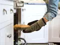 Persona saca un pastel del horno con guantes de cocina personalizados.