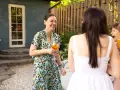 Mujeres sonriendo y bebiendo en una fiesta campestre.