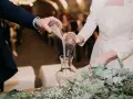 Manos unidas en el ritual de la arena boda, mezclando sus vidas en un solo recipiente.