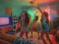 Chicas bailando en una fiesta temática de los 80, con luces de neón y música a todo volumen.