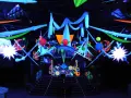 Decoración vibrante para una fiesta futurista, con luces neón, telas colgantes y estructuras geométricas que crean un ambiente de otro mundo.