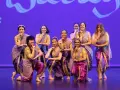 Un grupo de mujeres sonríe y posa con trajes vibrantes, listas para una fiesta bollywood.