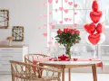 Mesa romántica con rosas, globos en forma de corazón y copas. ¡Perfectas ideas decoración San Valentín!