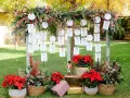Decoración boda civil sencilla y barata: mesa de invitados con tarjetas colgando de ramas y adornos navideños.