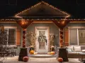 Encantadora decoración Halloween exterior casera con calabazas, luces cálidas y un porche acogedor.