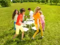Niños jugando a las sillas musicales, uno de los 20 juegos para fiestas infantiles.