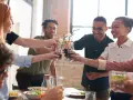 Grupo de amigos brindando con bebidas, inspirando temáticas para juegos de mesa y celebraciones.