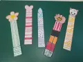 Cinco marcapáginas caseros: uno con flor, otro con corazón, uno con puntos, uno con un personaje y otro con un gatito.