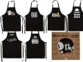 Varios delantales negros con frases divertidas para cocinar y asar: "Kiss the Cook", "Dad is Cooking", "Grill Master", "Insert Beer Here", "Mr. Good Lookin is Good Cookin" y "Grill Sergeant".