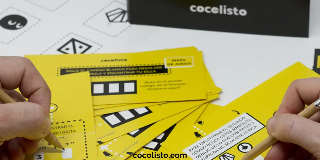Manos resolviendo juegos para comida de empresa con tarjetas amarillas y lápices. ¡Diversión garantizada!