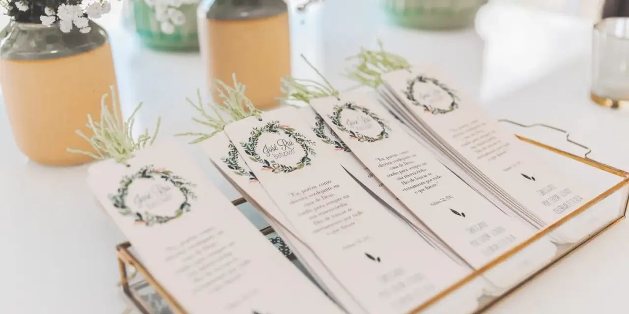 Detalle de invitaciones de boda caseras con diseño floral y versículos bíblicos, listas para entregar.