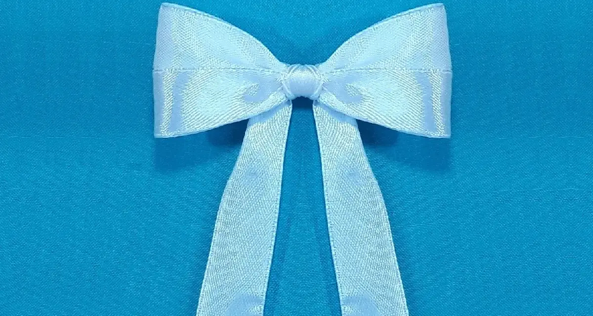 Un lazo blanco de satén, perfecto para decorar o hacer un regalo. Aprende a hacer lazo con cinta.