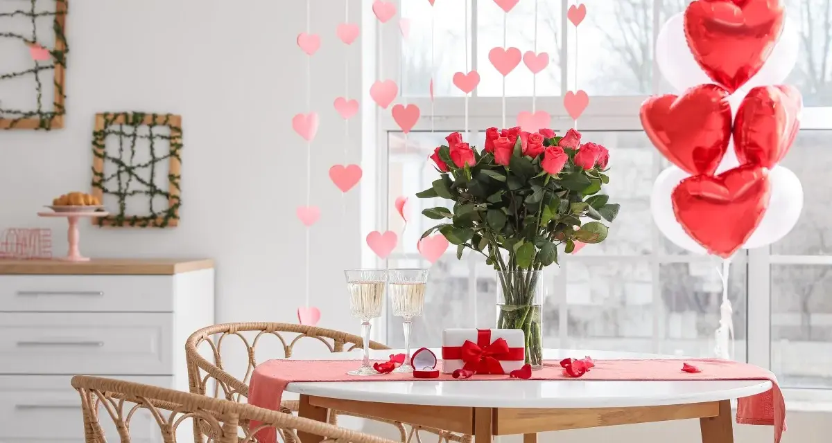 Mesa romántica con rosas, globos en forma de corazón y copas. ¡Perfectas ideas decoración San Valentín!