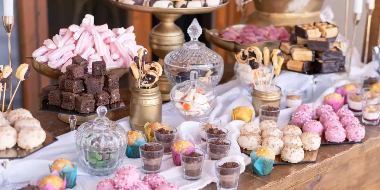 Mesa dulce para una boda: brownies, malvaviscos rosas, donuts, pastelitos y más. Un candy bar casero perfecto.