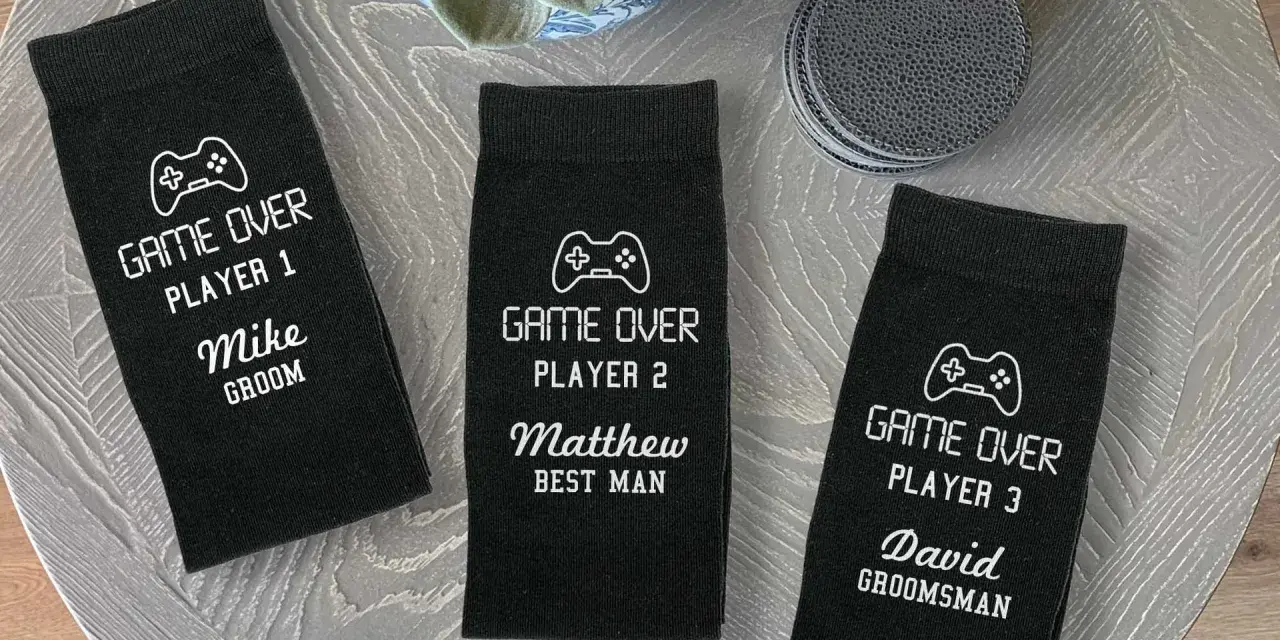 Tres calcetines negros personalizados con temática de videojuegos para boda, con nombres y roles.