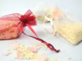 Bolsitas de organza rojas, blancas y melocotón llenas de arroz, listas para usarse como recuerdo. Ideas para como hacer bolsitas de arroz para bodas.