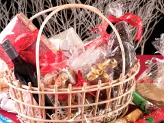 Canasta llena de dulces, galletas, una botella de vino y adornos navideños. ¡Perfecta para ideas para rifar!
