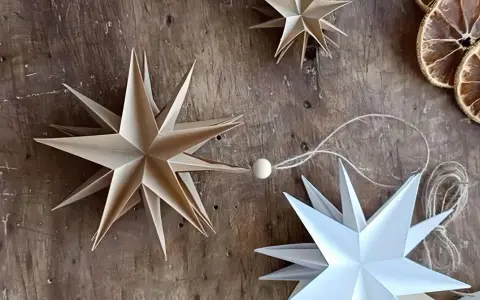 Estrellas de papel hechas a mano, perfectas manualidades adornos navideños caseros. Decoración rústica con rodajas de naranja seca.