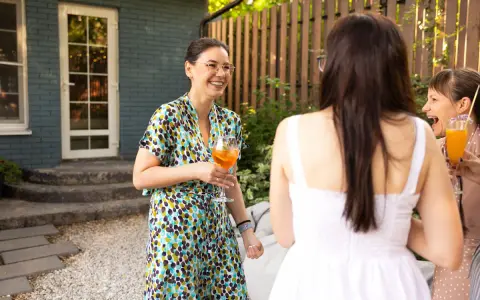 Mujeres sonriendo y bebiendo en una fiesta campestre.