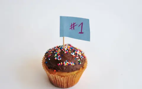 Magdalena con glaseado de chocolate y chispas de colores, lista para decorar. ¡El número 1!