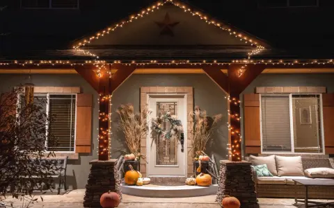 Encantadora decoración Halloween exterior casera con calabazas, luces cálidas y un porche acogedor.