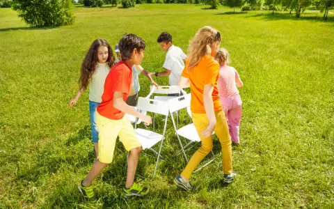 Niños jugando a las sillas musicales, uno de los 20 juegos para fiestas infantiles.