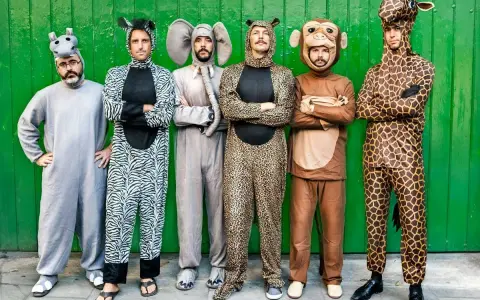Seis hombres posan con disfraces grupales caseros de animales: hipopótamo, cebra, elefante, leopardo, mono y jirafa.