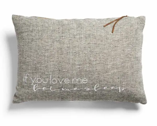 Cojines con frases: uno gris con "if you love me let me sleep" bordado en blanco y un detalle de cuero.