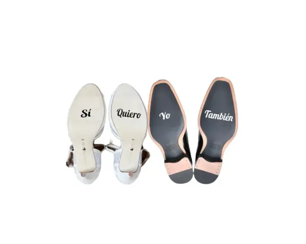 Pegatinas en zapatos de boda: "Sí, quiero" en tacones y "Yo también" en zapatos de hombre.