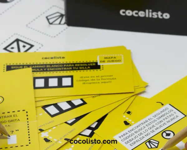 Manos resolviendo juegos para comida de empresa con tarjetas amarillas y lápices. ¡Diversión garantizada!