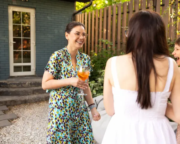 Mujeres sonriendo y bebiendo en una fiesta campestre.