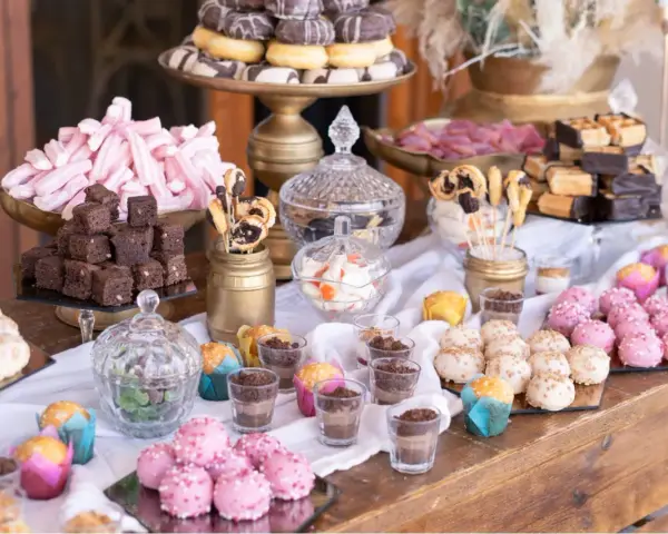 Mesa dulce para una boda: brownies, malvaviscos rosas, donuts, pastelitos y más. Un candy bar casero perfecto.