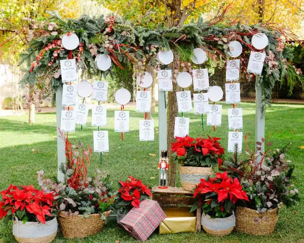 Decoración boda civil sencilla y barata: mesa de invitados con tarjetas colgando de ramas y adornos navideños.