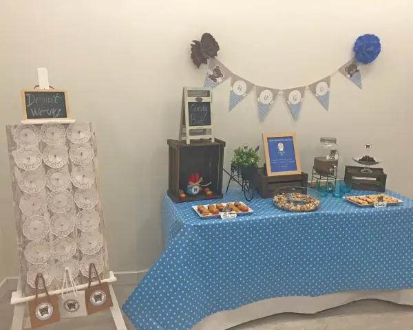 Mesa de dulces con temática de ositos, incluyendo un candy bar casero con magdalenas, galletas y palomitas.