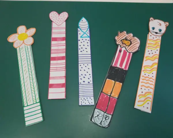 Cinco marcapáginas caseros: uno con flor, otro con corazón, uno con puntos, uno con un personaje y otro con un gatito.