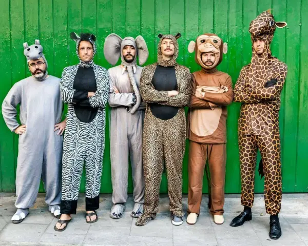 Seis hombres posan con disfraces grupales caseros de animales: hipopótamo, cebra, elefante, leopardo, mono y jirafa.
