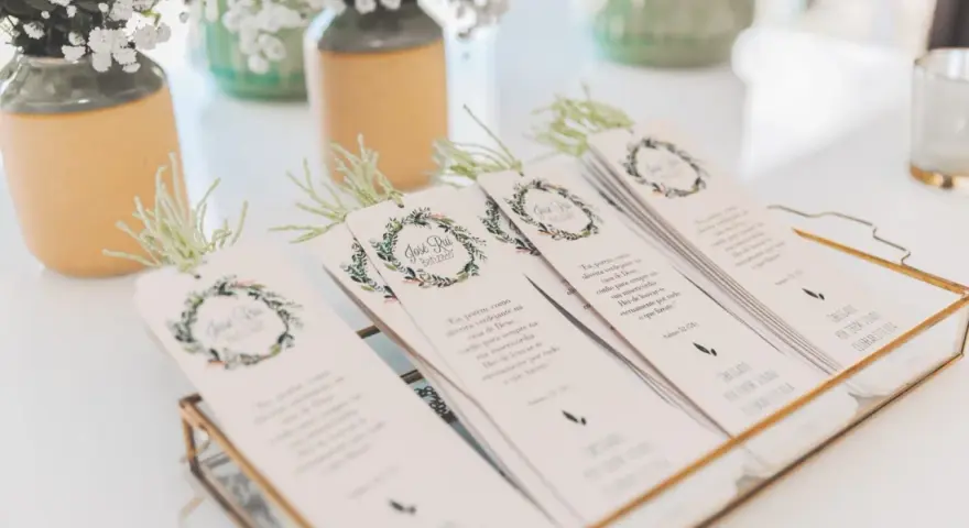 Detalle de invitaciones de boda caseras con diseño floral y versículos bíblicos, listas para entregar.