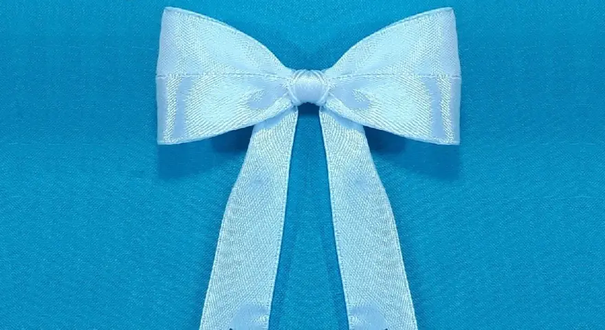 Un lazo blanco de satén, perfecto para decorar o hacer un regalo. Aprende a hacer lazo con cinta.