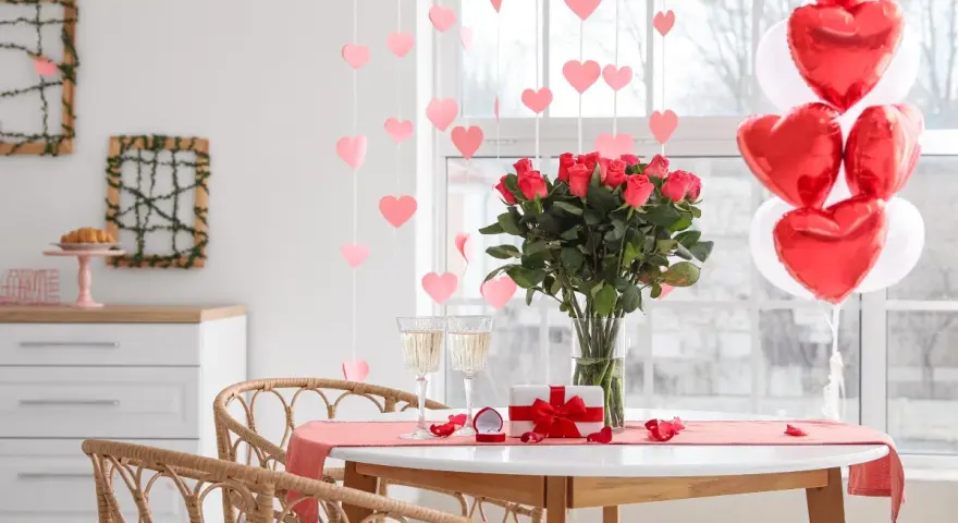 Mesa romántica con rosas, globos en forma de corazón y copas. ¡Perfectas ideas decoración San Valentín!