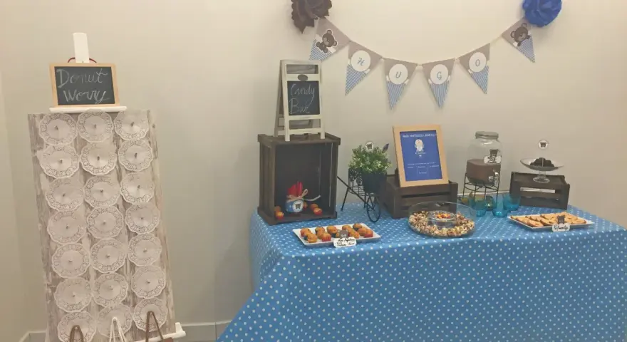 Mesa de dulces con temática de ositos, incluyendo un candy bar casero con magdalenas, galletas y palomitas.