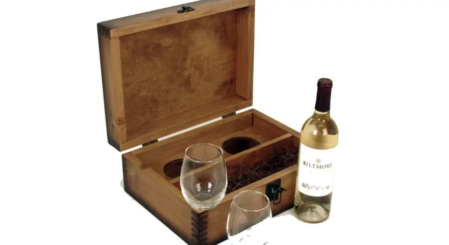 Caja de madera abierta con dos copas, paja decorativa y una botella de vino blanco. Un set vino personalizado perfecto para regalar.
