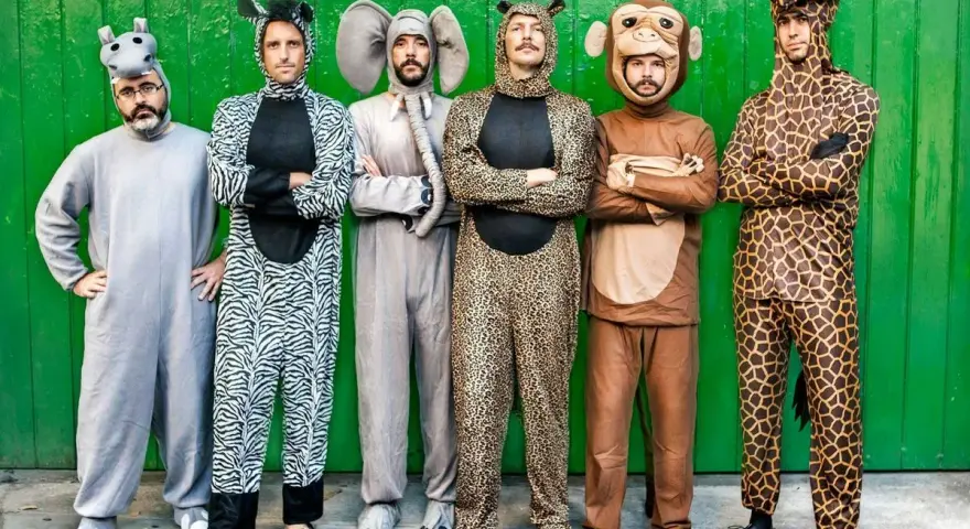 Seis hombres posan con disfraces grupales caseros de animales: hipopótamo, cebra, elefante, leopardo, mono y jirafa.
