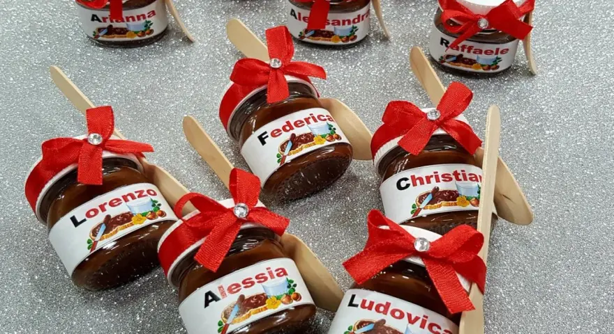 Mini tarros de Nutella personalizada con nombres como Lorenzo, Federica, Alessia, Christian, Ludovica, Arianna, Alessandra y Raffaele, adornados con lazos rojos.