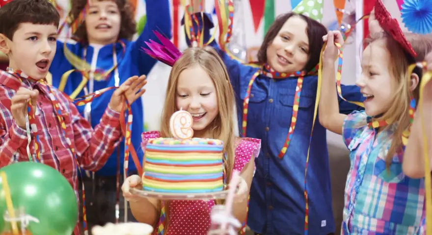 Niños celebran una temática fiesta infantil con pastel de cumpleaños, globos y serpentinas. ¡Alegría y diversión garantizadas!