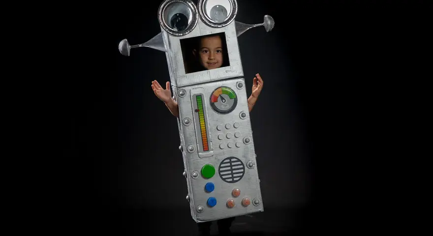 Niño con un divertido disfraz robot casero, con ojos saltones y panel de control. ¡Listo para la aventura!