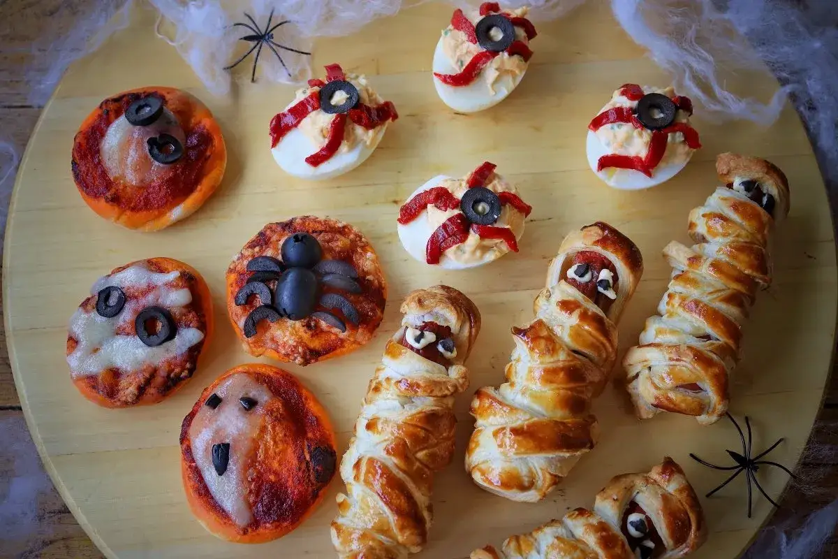 Deliciosas meriendas terroríficas: mini pizzas de araña y fantasma, huevos rellenos de ojos y salchichas momia. ¡Perfectas para Halloween!